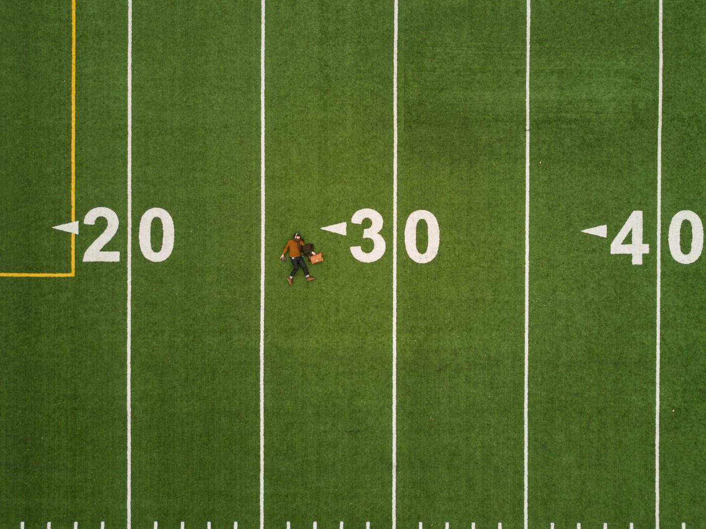 Aerial view of a green field with yard markers twenty, thirty and forty